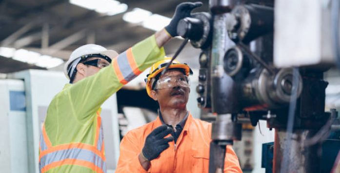 technician Having replacement machine With Mentor In Factory